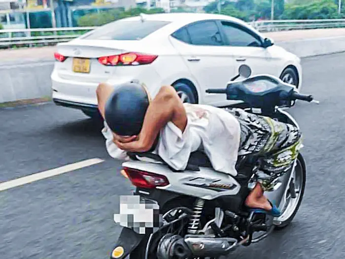 Người đàn ông thả hai tay lái xe máy trên cầu Rồng